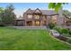 Large two-story brick home with multiple balconies and patios overlooking the expansive backyard at 6616 E Prentice Ave, Greenwood Village, CO 80111