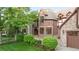 Beautifully landscaped home featuring lush greenery, brick accents, and a multi-car garage at 6616 E Prentice Ave, Greenwood Village, CO 80111