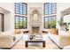 Bright living room with tall windows, a stone fireplace, and elegant furnishings at 6616 E Prentice Ave, Greenwood Village, CO 80111