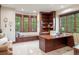 Home office featuring custom built-in shelving, a spacious desk, and a cozy window seat for reading at 6616 E Prentice Ave, Greenwood Village, CO 80111