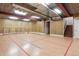 Unfinished recreation room with overhead beams, hockey nets, and a view of the upper staircase at 6616 E Prentice Ave, Greenwood Village, CO 80111