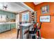 Bar area features a rustic wooden bar, brick wall, and opens to the kitchen at 3151 N Elizabeth St, Denver, CO 80205
