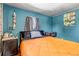 Stylish bedroom featuring exposed brick wall, blue accent wall, and hardwood floors at 3151 N Elizabeth St, Denver, CO 80205