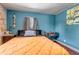 Stylish bedroom featuring exposed brick wall, blue accent wall, and hardwood floors at 3151 N Elizabeth St, Denver, CO 80205