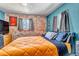 Stylish bedroom featuring exposed brick wall, blue accent wall, and hardwood floors at 3151 N Elizabeth St, Denver, CO 80205