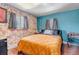 Stylish bedroom featuring exposed brick wall, blue accent wall, and hardwood floors at 3151 N Elizabeth St, Denver, CO 80205