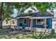 Charming brick home featuring a covered porch, red front door, and mature trees at 3151 N Elizabeth St, Denver, CO 80205