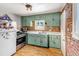 Traditional kitchen with light green cabinets, stainless steel appliances, and exposed brick accents at 3151 N Elizabeth St, Denver, CO 80205