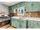 Bright kitchen featuring pale green cabinetry, white counters and stainless steel range at 3151 N Elizabeth St, Denver, CO 80205