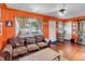 Living room features a leather sofa, wood flooring, and bright orange walls at 3151 N Elizabeth St, Denver, CO 80205