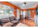 Living room with a leather couch, wood floors, orange walls and unique barrel decor at 3151 N Elizabeth St, Denver, CO 80205