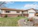 Home exterior featuring a brick facade, a green lawn, and garden area at 9698 Pecos St, Thornton, CO 80260