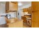 Kitchen with wood cabinets, countertop cooktop and a refrigerator at 9698 Pecos St, Thornton, CO 80260