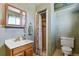 A cozy bathroom featuring a wood framed vanity, shower, and floral shower curtain at 1300 Kennedy Dr, Northglenn, CO 80234