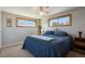Cozy bedroom with a plush blue bedspread and natural light from the two large windows at 1300 Kennedy Dr, Northglenn, CO 80234
