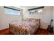 This bedroom includes two windows, a full sized bed, a guitar, and red carpeting at 1300 Kennedy Dr, Northglenn, CO 80234