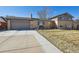 Charming two-story home featuring a long driveway and a classic brick facade at 1300 Kennedy Dr, Northglenn, CO 80234