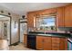 Well-maintained kitchen with wooden cabinets, black appliances, and a view to the outside at 1300 Kennedy Dr, Northglenn, CO 80234