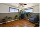 Bright living room with lots of plants near the natural light windows and a chair near a wood floor at 1300 Kennedy Dr, Northglenn, CO 80234