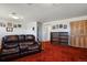 Carpeted living room featuring a leather couch, pictures on the wall, bookshelves, and closet doors at 1300 Kennedy Dr, Northglenn, CO 80234