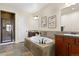 A full bathroom features a large soaking tub with stone surround, a tile floor, and dual sink vanities at 9450 Sori Ln, Highlands Ranch, CO 80126