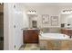 A full bathroom features a large soaking tub with stone surround, a tile floor, and dual sink vanities at 9450 Sori Ln, Highlands Ranch, CO 80126