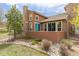 Back exterior view with stone chimney, manicured lawn, and a serene outdoor patio at 9450 Sori Ln, Highlands Ranch, CO 80126
