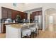 Spacious kitchen features a large island with seating, stainless steel appliances, and beautiful dark wood cabinetry at 9450 Sori Ln, Highlands Ranch, CO 80126