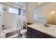 Bathroom with shower and bathtub featuring tile surround, window, white countertops, and dark grey cabinets at 1558 White Violet Way, Louisville, CO 80027