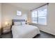 Bright bedroom featuring a large window, stylish nightstands, and comfortable-looking bed at 1558 White Violet Way, Louisville, CO 80027