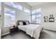 Bright bedroom featuring large windows, a cozy bed, and stylish decor at 1558 White Violet Way, Louisville, CO 80027