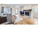 Bright living room with hardwood floors, a stone fireplace, and cozy seating, creating an inviting atmosphere at 1558 White Violet Way, Louisville, CO 80027