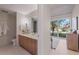 Bright bathroom featuring double sink vanity, modern fixtures, and a view of outside greenery at 1620 Little Raven St # 103, Denver, CO 80202