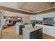 Bright, open kitchen with white cabinets, stainless steel appliances, and a view of the living room fireplace at 9249 Fox Fire Dr, Highlands Ranch, CO 80129