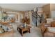 Inviting living room featuring a curved staircase, neutral decor, and a connecting dining area at 9249 Fox Fire Dr, Highlands Ranch, CO 80129