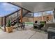 Covered outdoor patio area with comfortable seating and a view of the landscaped backyard at 9249 Fox Fire Dr, Highlands Ranch, CO 80129