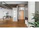 Entryway featuring hardwood floors, exposed pipes, and an accent wall with decorative artwork at 1863 Wazee St # 6E, Denver, CO 80202