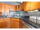 Well-lit kitchen features wood cabinets, black countertops, stainless steel appliances, and wood floors at 1863 Wazee St # 6E, Denver, CO 80202