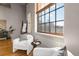 Cozy living space with comfortable chairs, hardwood floors, and a large window offering great views of the city skyline at 1863 Wazee St # 6E, Denver, CO 80202