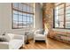 Two white armchairs and large windows in the living room at 1863 Wazee St # 6E, Denver, CO 80202