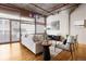 Bright living room with large windows, concrete columns, hardwood floors, and modern decor at 1863 Wazee St # 6E, Denver, CO 80202