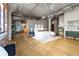 Stylish main bedroom featuring exposed concrete, hardwood floors, and modern furnishings, including artwork and plants at 1863 Wazee St # 6E, Denver, CO 80202