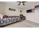 Carpeted bedroom featuring a ceiling fan, a wall-mounted TV, and superhero themed decor at 23545 E Platte Dr # C, Aurora, CO 80016