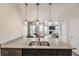Open-concept kitchen featuring a granite countertop island with a stainless steel sink and stylish pendant lights at 23545 E Platte Dr # C, Aurora, CO 80016