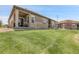 Grassy backyard with a covered patio and stone accents at 25059 E Alder Dr, Aurora, CO 80016