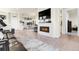 Bright living room featuring an electric fireplace, TV, and open floor plan to the kitchen at 25059 E Alder Dr, Aurora, CO 80016