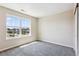 An inviting bedroom offers neutral carpeting and a large window providing natural light and neighborhood views at 3823 Horiuchi St, Brighton, CO 80601