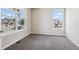 Bright bedroom featuring neutral carpet, two windows, and ample natural light at 3823 Horiuchi St, Brighton, CO 80601