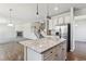 Modern kitchen includes stainless steel appliances, a spacious island, and opens into living area at 3823 Horiuchi St, Brighton, CO 80601