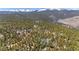 A beautiful aerial view of a treed lot and mountains in the background at 14800 Gold Hill Rd, Boulder, CO 80302